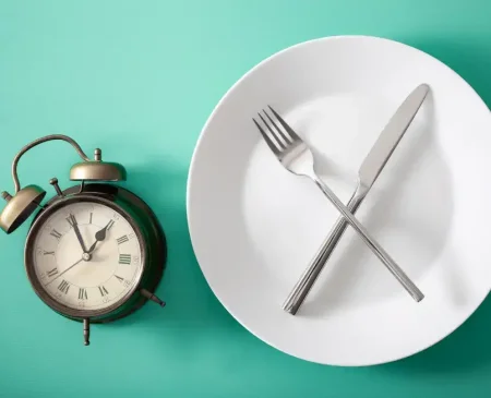 Clock With Empty Plate And Cutlery Illustrating How To Make Fasting Work For You | Gym Plus
