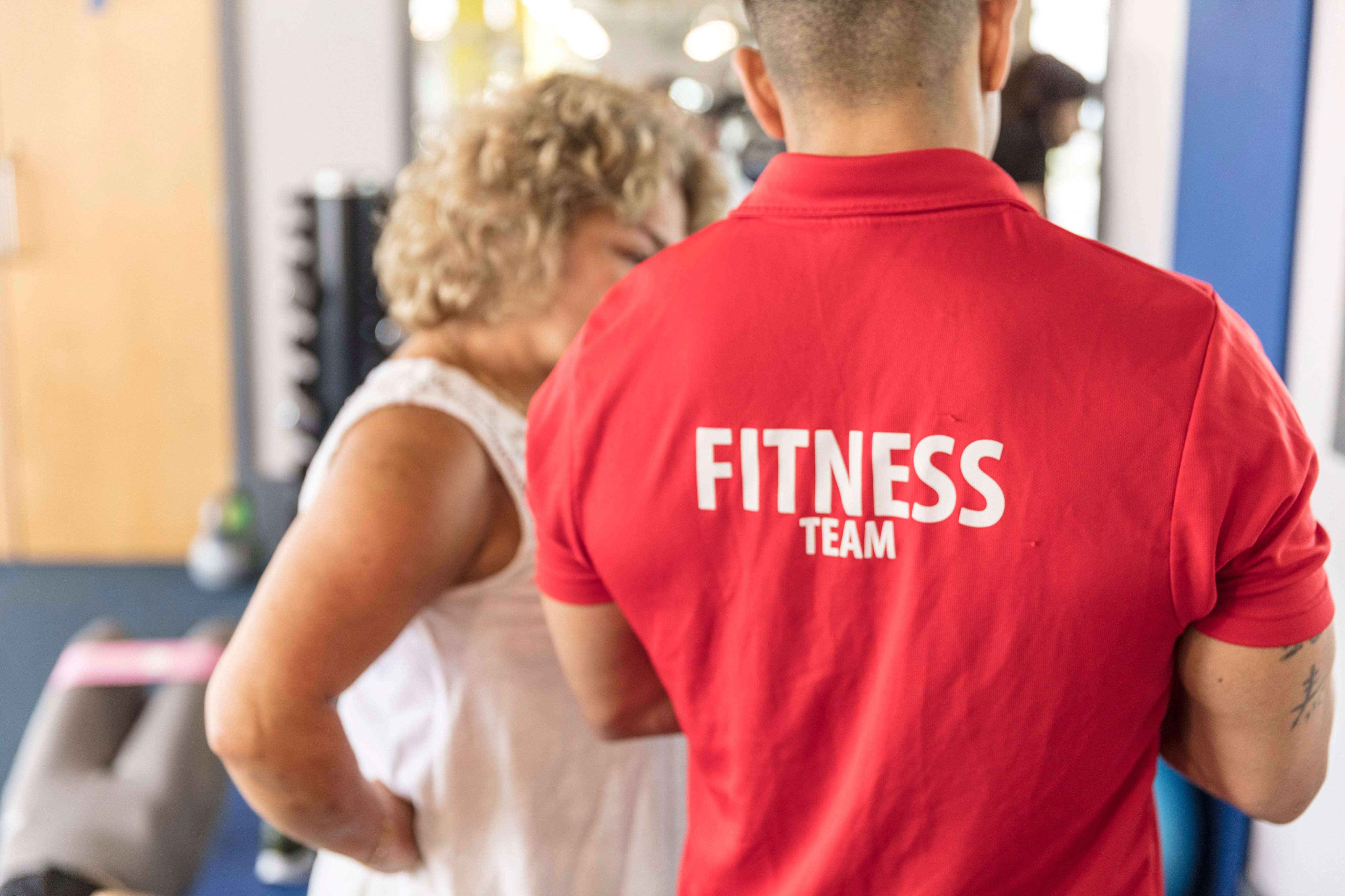 Gym Plus Staff Member talking to a member