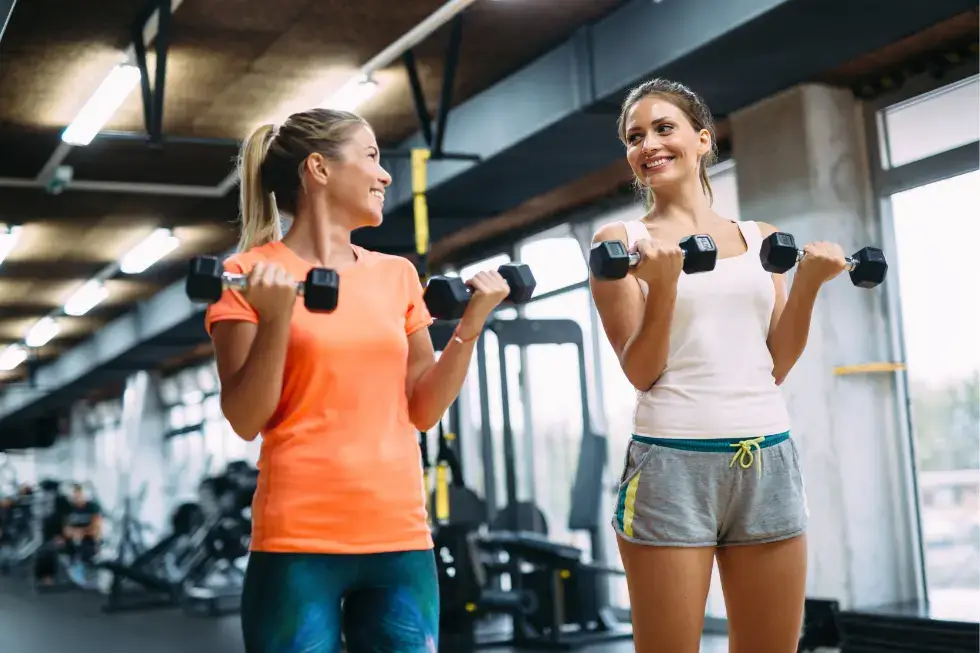 Women lifting dumbbells during a strength training workout at Gym Plus celebrating International Women’s Day