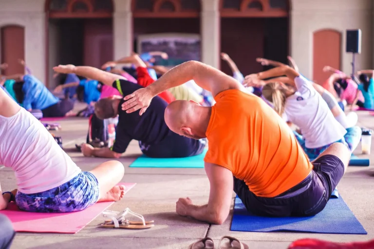 Yoga for beginners at Gym Plus, with a group practising yoga poses on mats during a class.