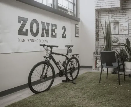 Zone 2 Training Bike In A Gym With Zone 2 Heart Rate Guidance On The Wall.