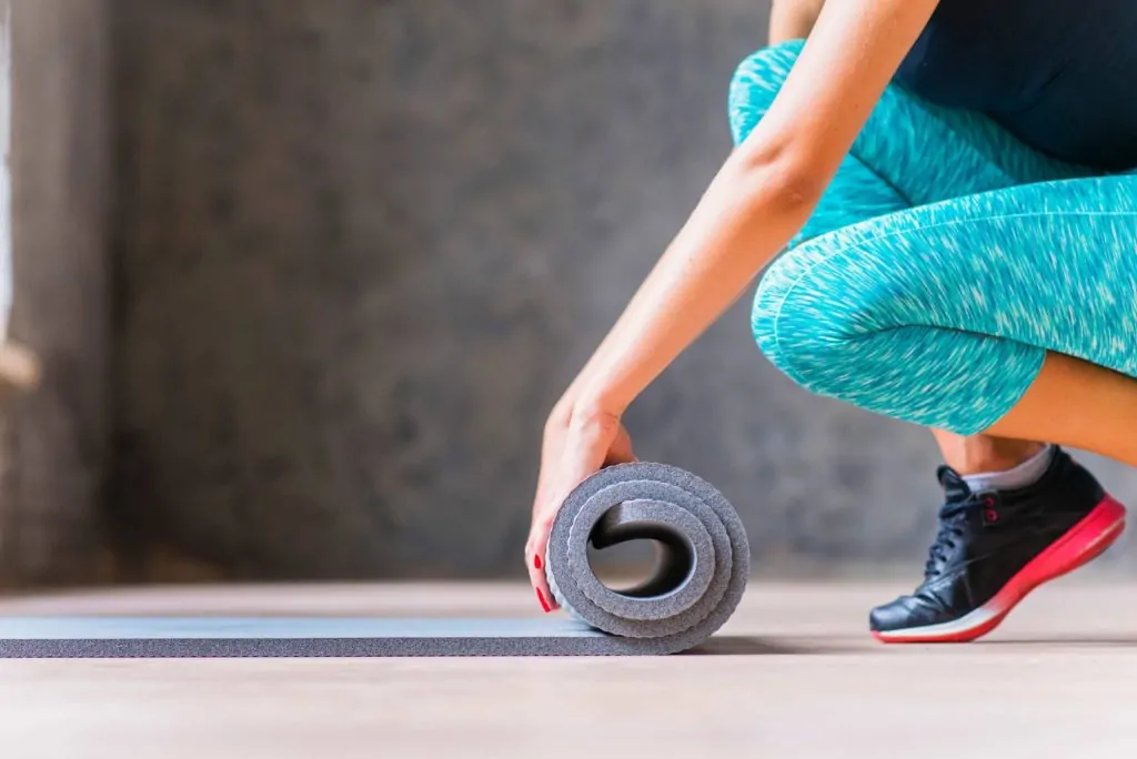 Woman rolling an exercise mat